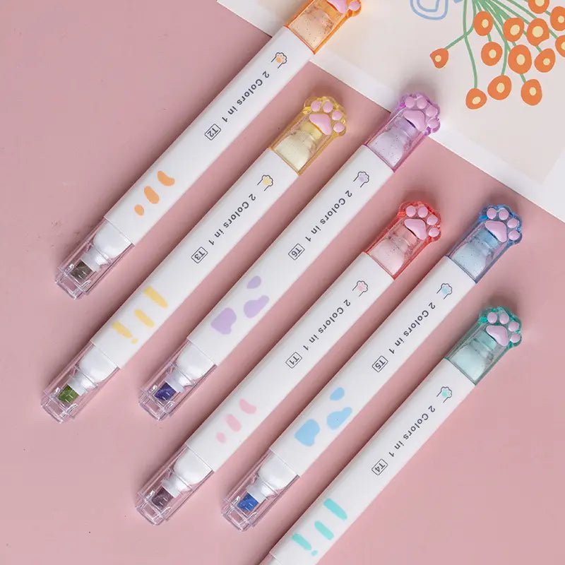 Set of 6 cute cat paw dual tip highlighter pens placed upon a pink pastel background